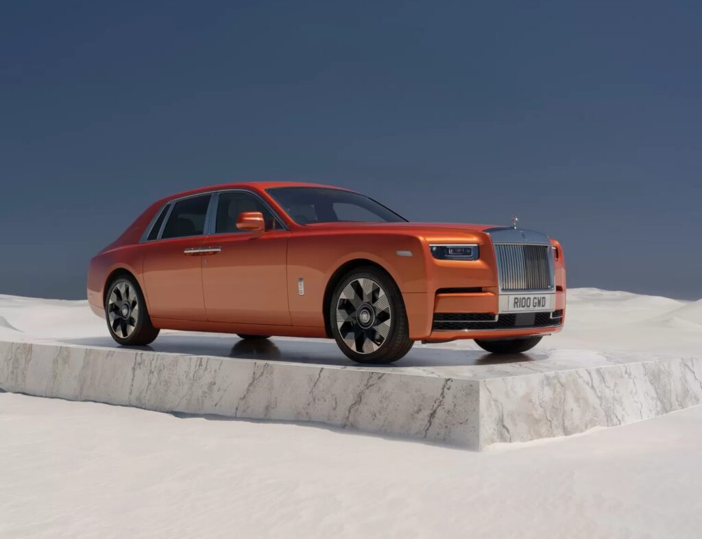 Orange ultra-luxury sedan on a marble platform in a desert setting